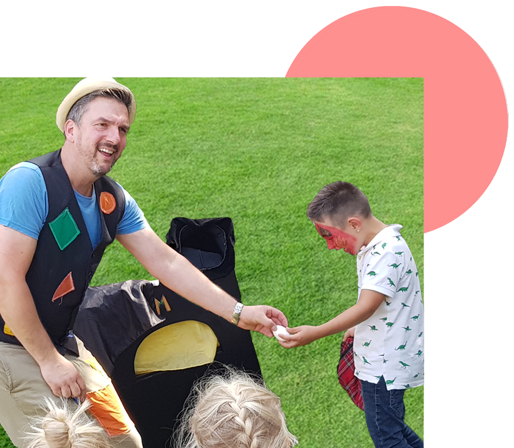 Pino Magino bezieht ein Kind bei einer Zaubershow im Freien in einen Trick ein
